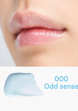 Close-up of lips with a small amount of blue lip balm labeled '000 Odd sense' on a white background.