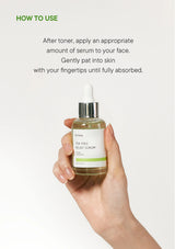 Hand holding a bottle of tea tree relief serum with usage instructions on a white background