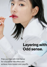 Person applying lip product with text 'Layering with Odd Sense' on a white background