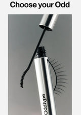 Mascara with false eyelashes being applied, featuring the brand 'oddtypes' on a gray background.