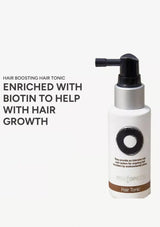 Hair tonic bottle with text about biotin and hair growth on a white background