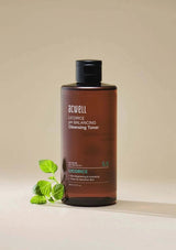 Brown bottle of ACWELL Licorice pH Balancing Cleansing Toner with licorice leaves on a beige background