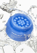 Blue jar of Medicube product with water droplets and splashes on a white background