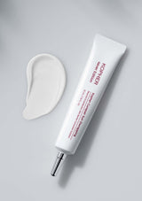 Kiehl's skincare product with applicator on a gray background