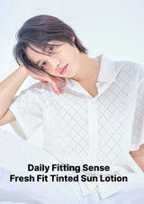A model wearing a white short-sleeve collared shirt with a subtle grid pattern, posing against a bright white background. Text at the bottom reads 'Daily Fitting Sense Fresh Fit Tinted Sun Lotion'.