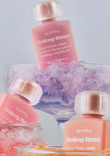 Pink lip potion bottles with 'Balmy Rose' branding on a light gray background