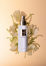Skincare bottle with flowers on a beige background