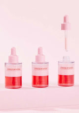 Three dropper bottles with pink liquid labeled 'every routine' on a light pink background.