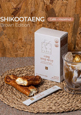 Packaging of SHIKOOTAENG Diet Coffee Hazelnut with text detailing the product name, weight per stick, and the box containing 30 sticks.