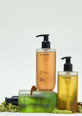 Three bottles of hersteller products on a light gray background