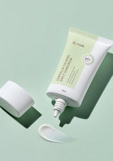 Tub of IUNIK sunscreen on a light green background