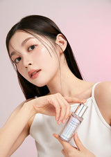 Woman holding a skincare bottle against a pink background