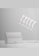 White skincare product packaging with multiple tubes on a gray background