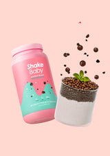Shake Baby protein powder container with a cup of chia pudding on a pink background
