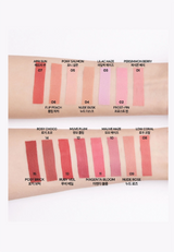 A swatch chart showing multiple lipstick shades applied on skin, with shade names and numbers printed above and below each color block. The shades include april sun, pony salmon, lilac haze, frosty pink, persimmon berry, flip peach, nude zuck, ruby vel, magenta bloom, and low coral.