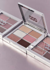 Makeup palette with various shades of pink and brown on a light purple background