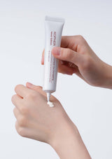 Hand applying KORPER product to another hand against a white background