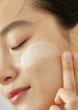 Close-up of a person applying cream to their face