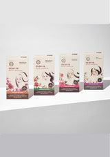 Four boxes of a cosmetic product with floral and portrait designs on a white background