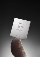 AIDA skincare mask packaging on a gradient background