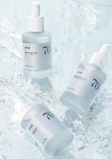 Three skincare droppers with '70' branding on a light blue textured background