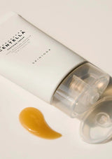 Skincare cream tube with a swatch of cream on a light background