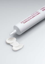 White tube of dental cement with a small amount on a gray background