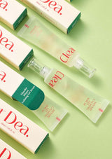Cosmetic products with 'Dea' branding on a green background