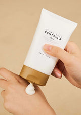 Hand holding a tube of Skinceuticals Centella Cream against a beige background