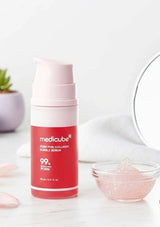 Medicube skincare product on a white surface with a small bowl of pink powder.
