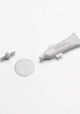 Skincare product with applicator on a white background