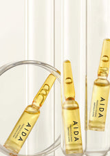AIDA skincare ampoules on a white background
