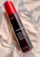 Medicated red acne peel product bottle on a light fabric background