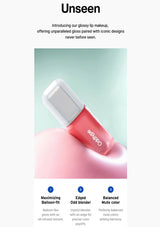 Pink lip gloss with white cap on a light green background, featuring the brand 'Unseen'.