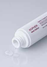 Kopher skincare product with droplet on gray background