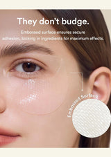 Close-up of a woman's eye area showing a transparent under-eye patch applied under the eye, with marketing text reading 'They don't budge.' and a circular inset labeled 'Embossed Surface' showing the textured adhesive backing.