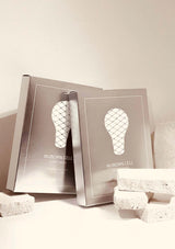 Two silver boxes with a light bulb design on a beige background