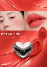 Lipstick with a heart-shaped cap on a white background, featuring a model wearing the lipstick.