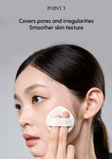 Person applying a skincare product to their face with a gray background