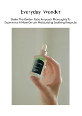 Hand holding a bottle of 'Everyday Wonder' ampoule with text on a plain background
