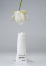 White bottle with a flower on a gray background