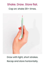 Hand holding a mint MERRYMONDE Super Twim pen with shake-before-use and horizontal-storage directions
