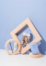 Cosmetic products and a photo frame on a light blue background