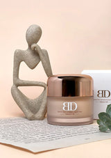 Cosmetic jar with 'BD' branding on a surface with decorative elements