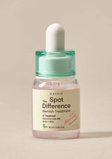 Bottle of Axis-Y Spot Difference Blemish Treatment on a beige background