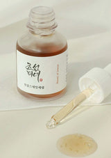 Skincare serum bottle with dropper on a light background