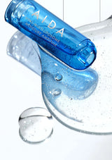 Blue AIDA skincare product with droplets on a white background