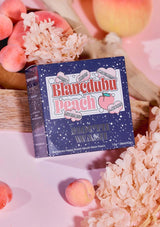 Blancedubu Peach skincare product packaging with peaches and flowers in the background