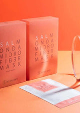 Two salmon-colored boxes of 'Salmon Microfiber Mask' on an orange background
