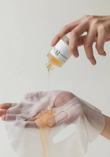 Person pouring a liquid from a bottle labeled 'W8' onto their hand against a light background